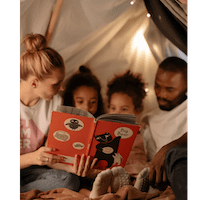 Family reading in a tent two children barely visible over the top of a book. Woman on the left and Man on the right of the kids